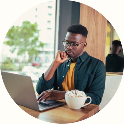 A handsome young businessman looking at laptop and focusing on work in a coffee shop