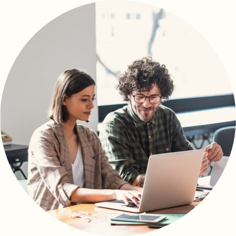 Man and Woman Sitting at the Office and Working Together on a Laptop