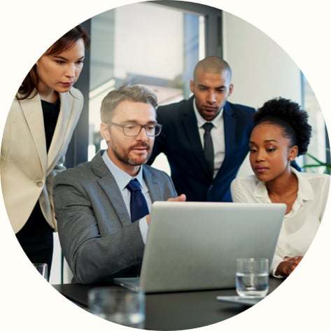 group of business colleagues looking at laptop in the boardroom 