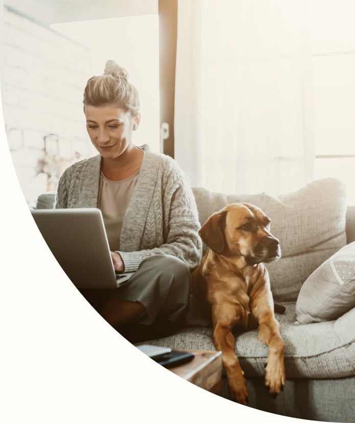 woman and her dog reading laptop on a couch 